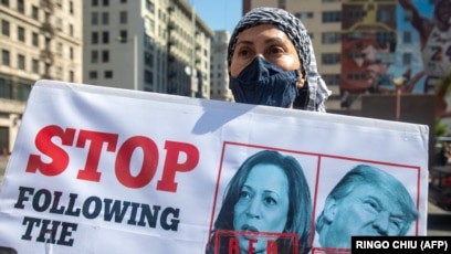 papan bergambar Kamala Harris dan Donald Trump