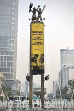Aktivis Greenpeace Indonesia bentangkan spanduk raksasa Tangani Krisis Iklim di Patung Selamat Datang Bundaran HI Jakarta