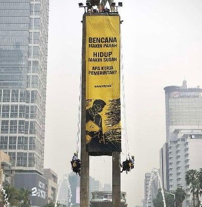 Aktivis Greenpeace Indonesia bentangkan spanduk raksasa Tangani Krisis Iklim di Patung Selamat Datang Bundaran HI Jakarta